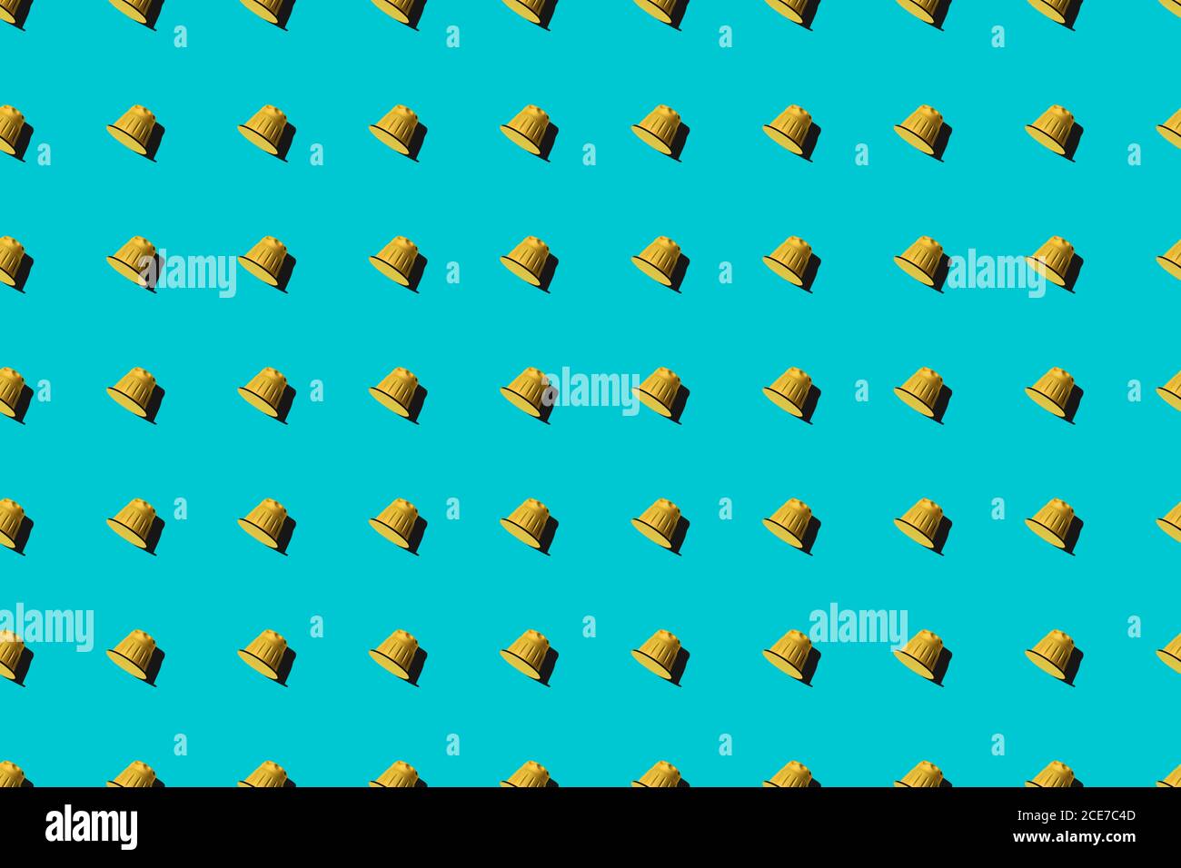Ansicht der gelben Kaffeepads in geraden Reihen Als nahtloses Muster auf blauem Hintergrund Stockfoto