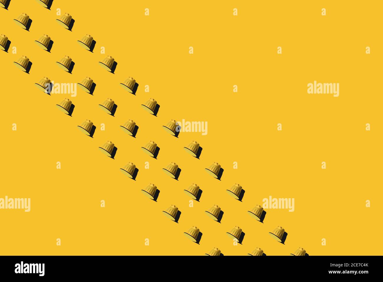 Ansicht der gelben Kaffeepads in geraden Reihen Als nahtloses Muster auf gelbem Hintergrund Stockfoto