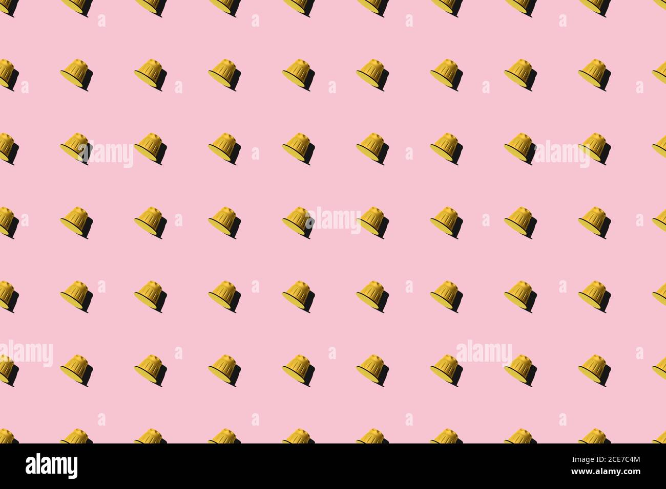 Ansicht der gelben Kaffeepads in geraden Reihen Als Nahtloses Muster auf rosa Hintergrund Stockfoto