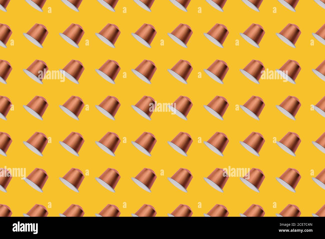 Draufsicht auf goldene Kaffeepads in geraden Reihen Als nahtloses Muster auf gelbem Hintergrund Stockfoto