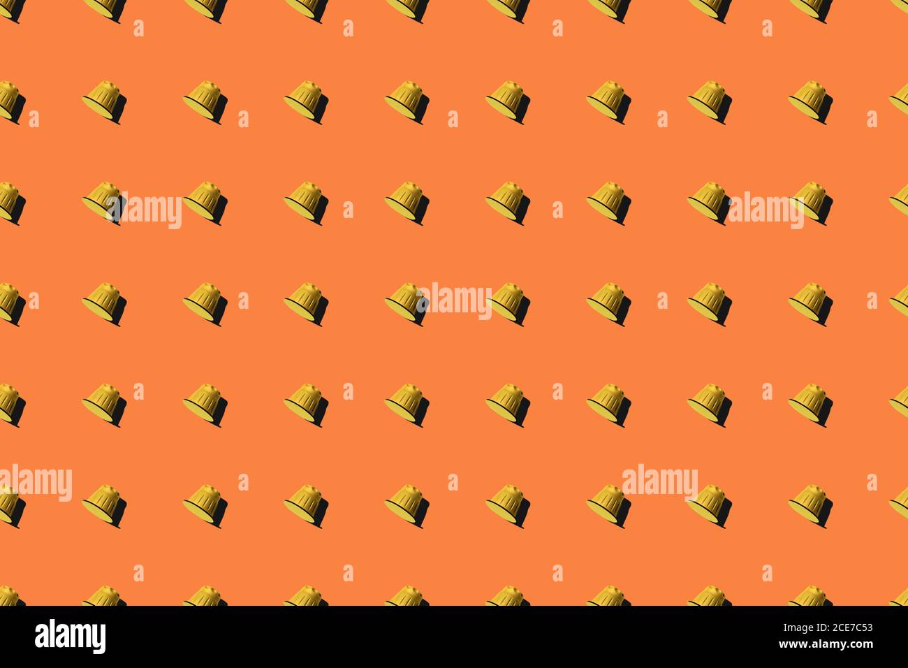 Ansicht der gelben Kaffeepads in geraden Reihen Als nahtloses Muster auf orangefarbenem Hintergrund Stockfoto