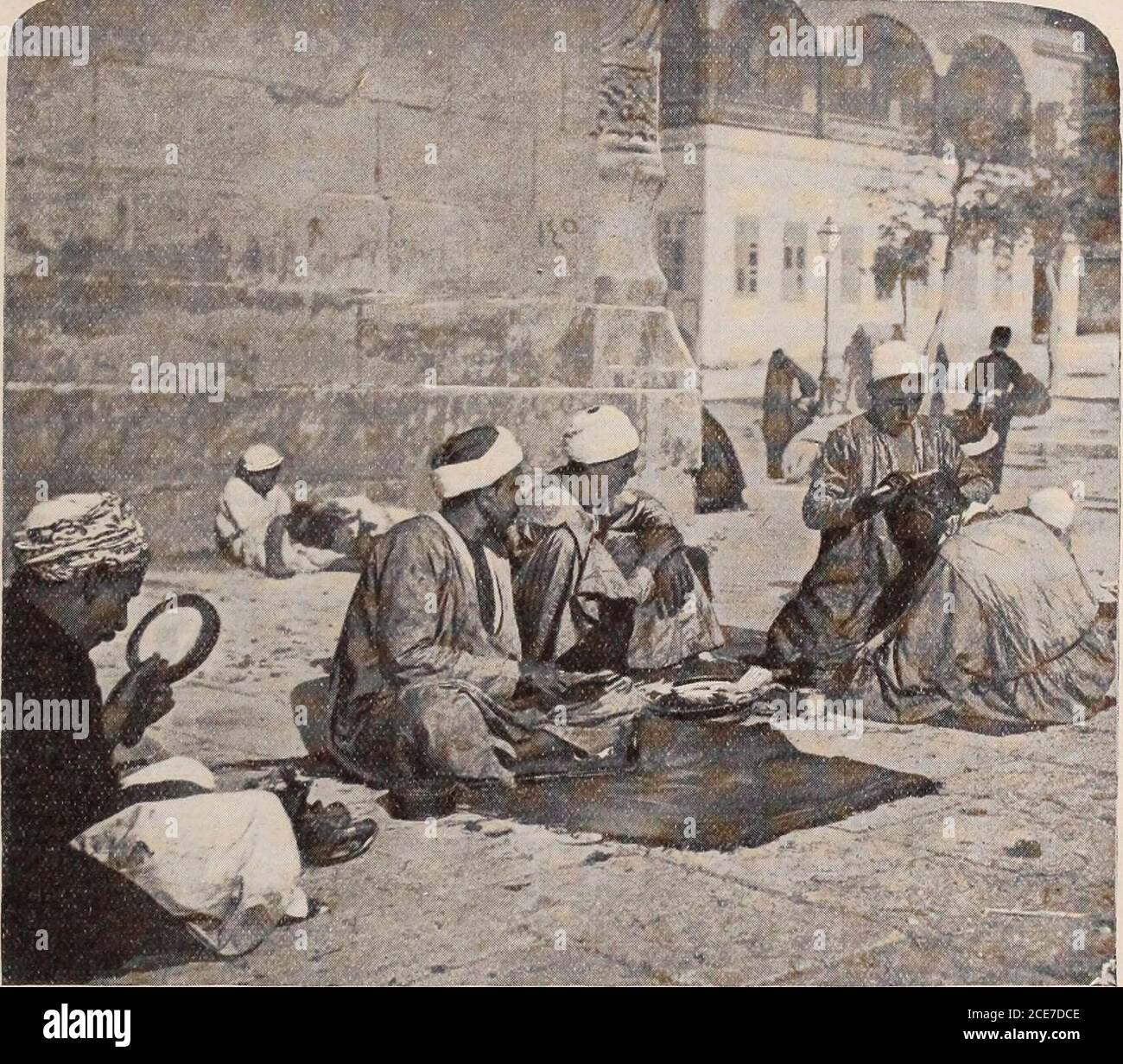 . Christian Herald und Zeichen unserer Zeit. rast auf die Neuheit und Barheit des Lebens in Port Said und sein Mangel an malerischen Umgebung, sind die Szene  LW AT  , die den Reisenden in Kairo begrüßen, einer der ältesten von Ägyptens bemerkenswerteste. Unser Fotograf hat uns in der Abbildung auf dieser Seite eine Idee von einigen der seltsamen Straßenattraktionen gegeben, die dort zu verzaubern sind – ein orientalischer Barbier, seine Kunden knieten auf Teppichen, die auf den Steinen eines öffentlichen Platzes, oderInnenhof, verteilt sind. Zu seinem Besuch in Kairo, Hon. Z. T. Sweeney schrieb: Kairo ist eine viel handsomer Stadt thanAlexandria, und mehr Th Stockfoto