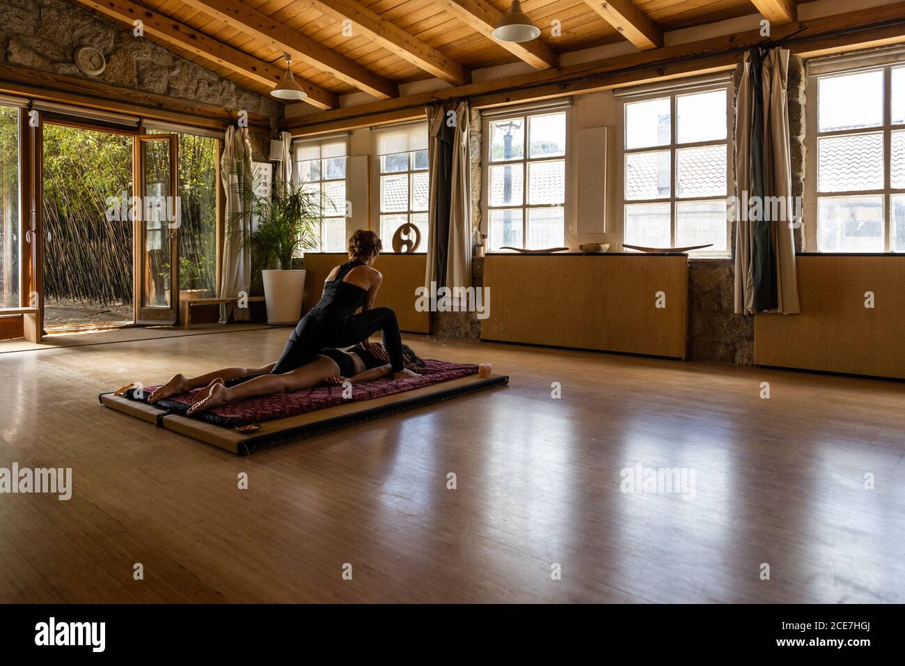 Rückansicht der weiblichen Instruktor tun Massage für Partner nach Yoga-Praxis im Studio Stockfoto