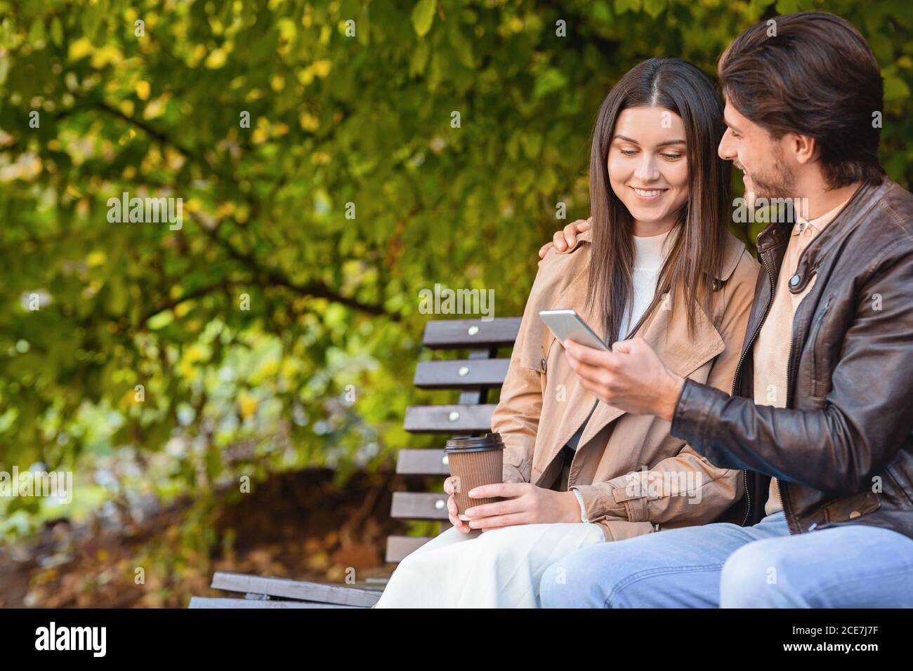 Mann und Frau sitzen auf der Bank und beobachten Fotos Stockfoto