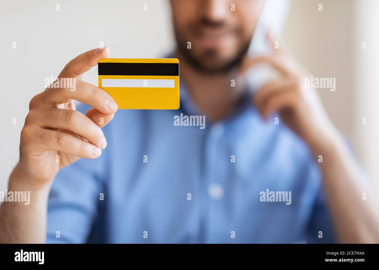 Online-Banking. Unkenntlich Mann Hält Kreditkarte Und Sprechen Auf Handy Stockfoto