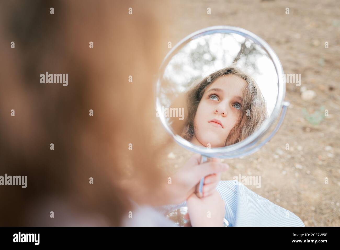 Wehmütig Kind mit blauen Augen und braunen Haaren wegschauen Beim  Reflektieren in runden Spiegel in der Wohnung bei Tageslicht  Stockfotografie - Alamy
