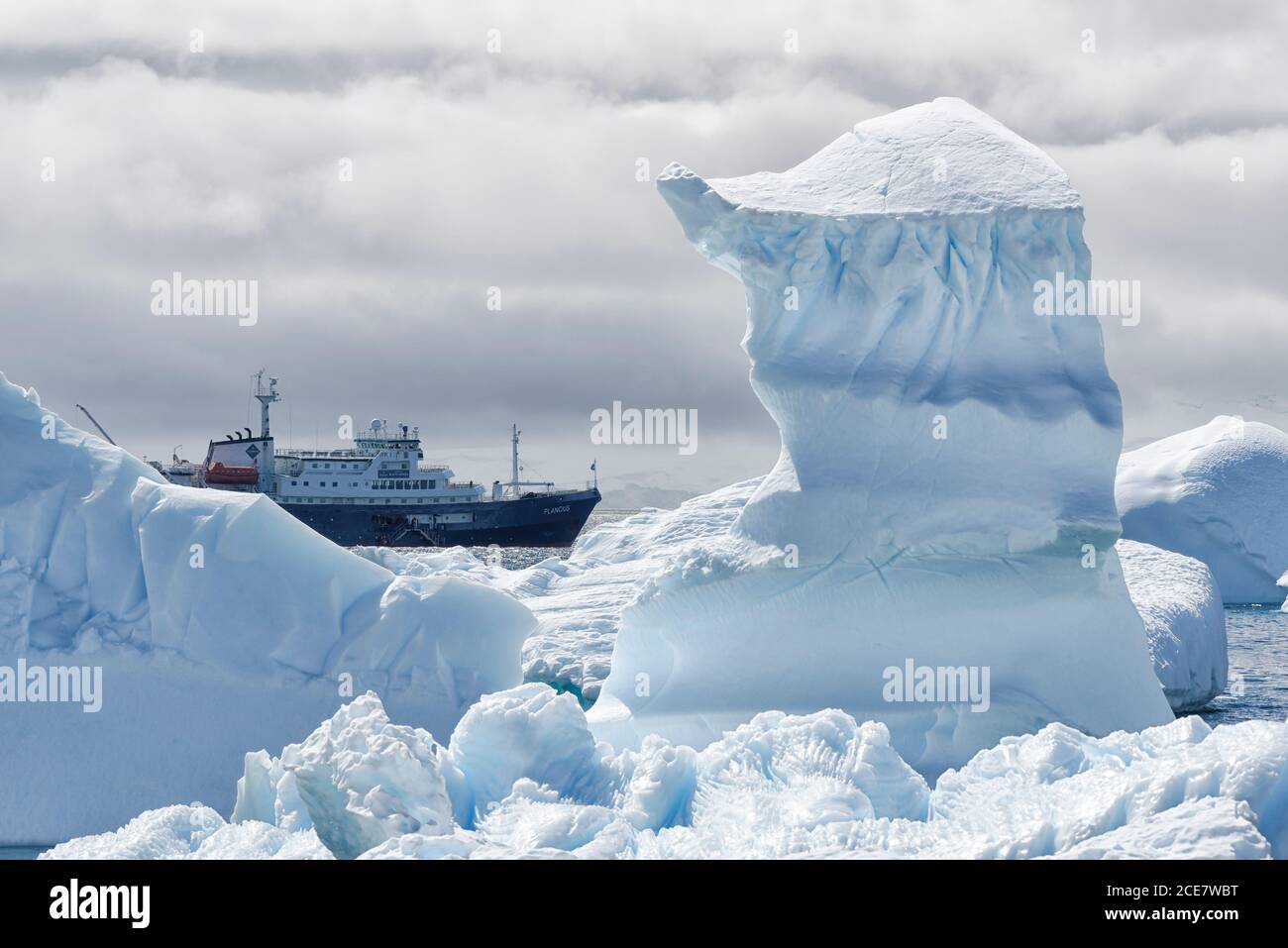 Blick zwischen zwei Schneespitzen auf ein kleines Kreuzschiff, Antarktische Halbinsel, West Antarktika Stockfoto