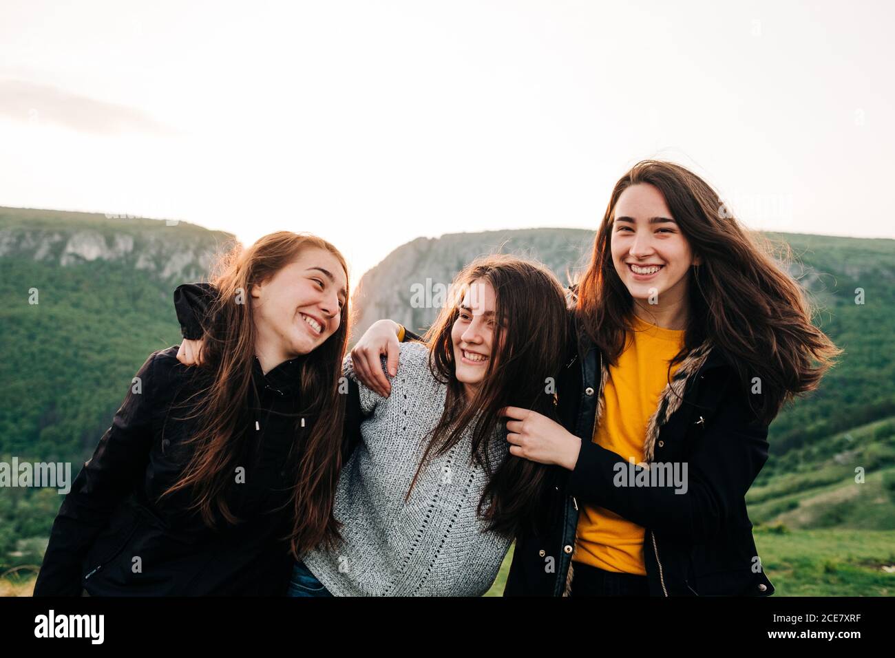 Entzückte Freundinnen umarmen zusammen auf dem Hintergrund der erstaunlichen Hochland-Landschaft Während der Urlaub in Siebenbürgen Stockfoto