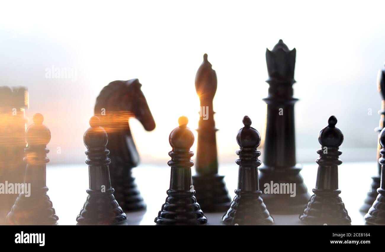 Schachfiguren mit Sonnenlicht, das durch sie strömt Stockfoto