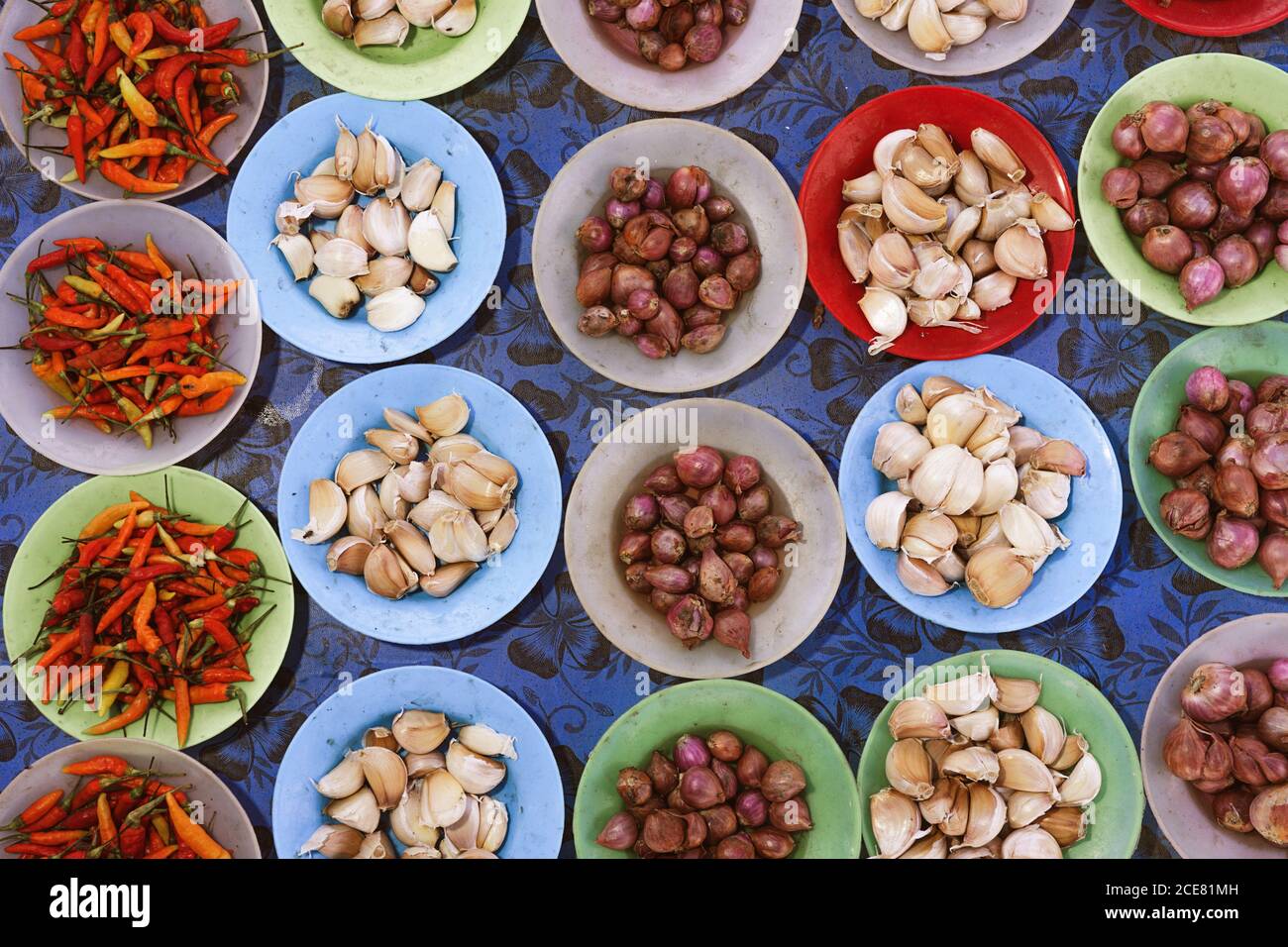 Draufsicht auf Knoblauch und Zwiebeln in Schüsseln platziert Theke mit getrockneten Chilischoten im lokalen Basar Stockfoto