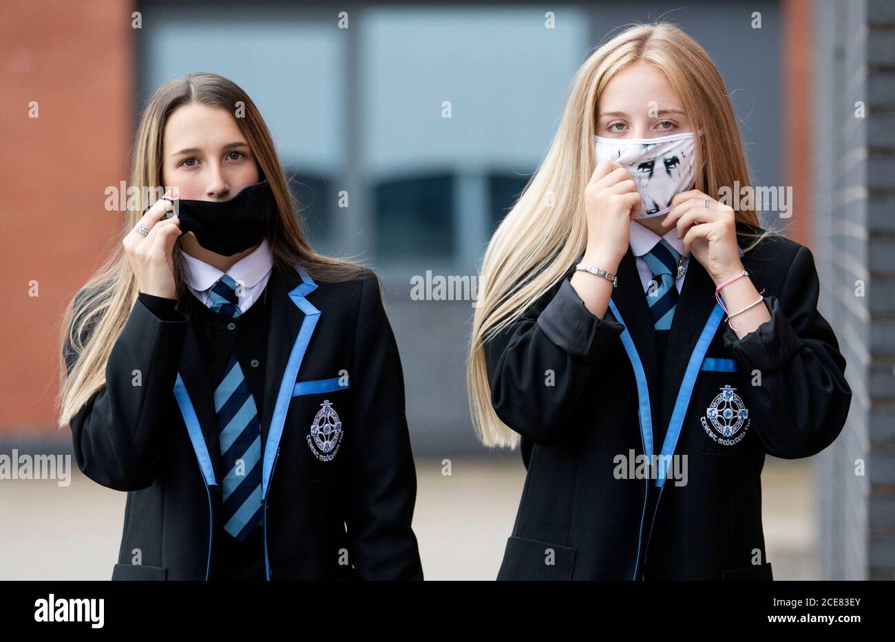 Leah McCallum (links) und Rebecca Ross, S4-Studenten an der St Columba's High School, Gourock, ziehen ihre schützenden Gesichtsmasken an, da Schüler der Sekundarstufe ab heute in ganz Schottland Gesichtsbezüge tragen müssen, wenn sie in der Schule unterwegs sind. Stockfoto