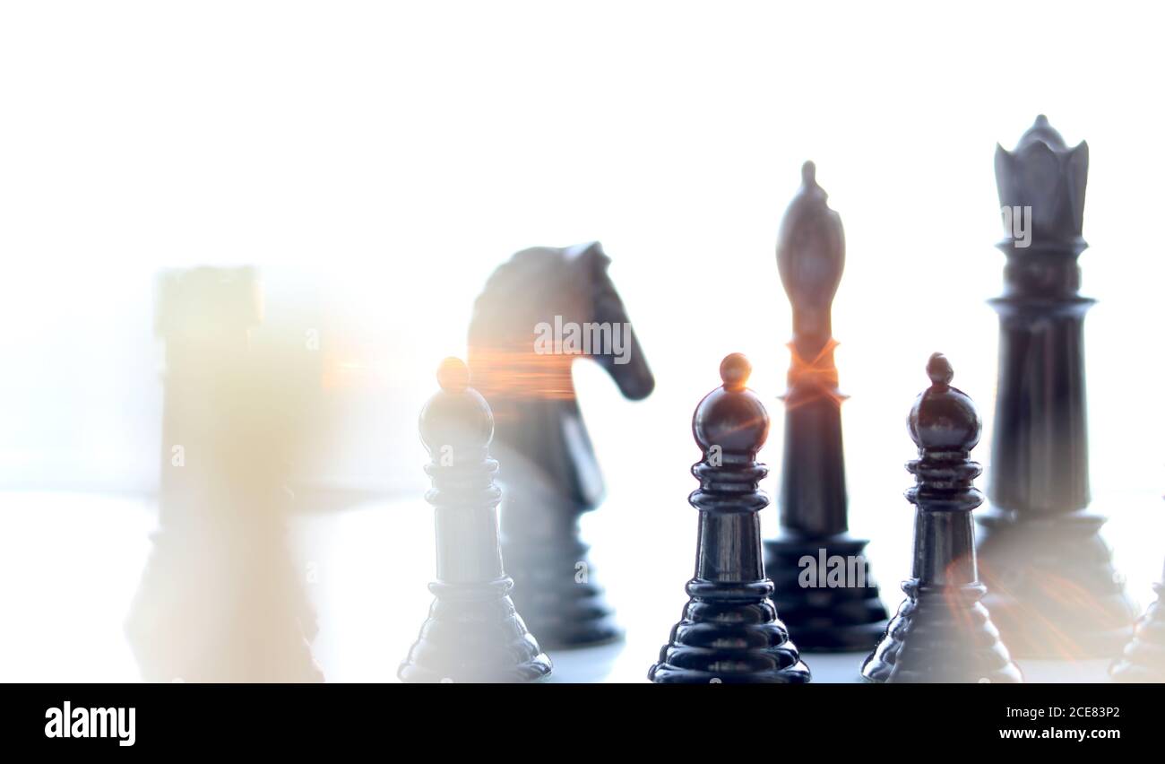 Schachfiguren mit Sonnenlicht, das durch sie strömt Stockfoto