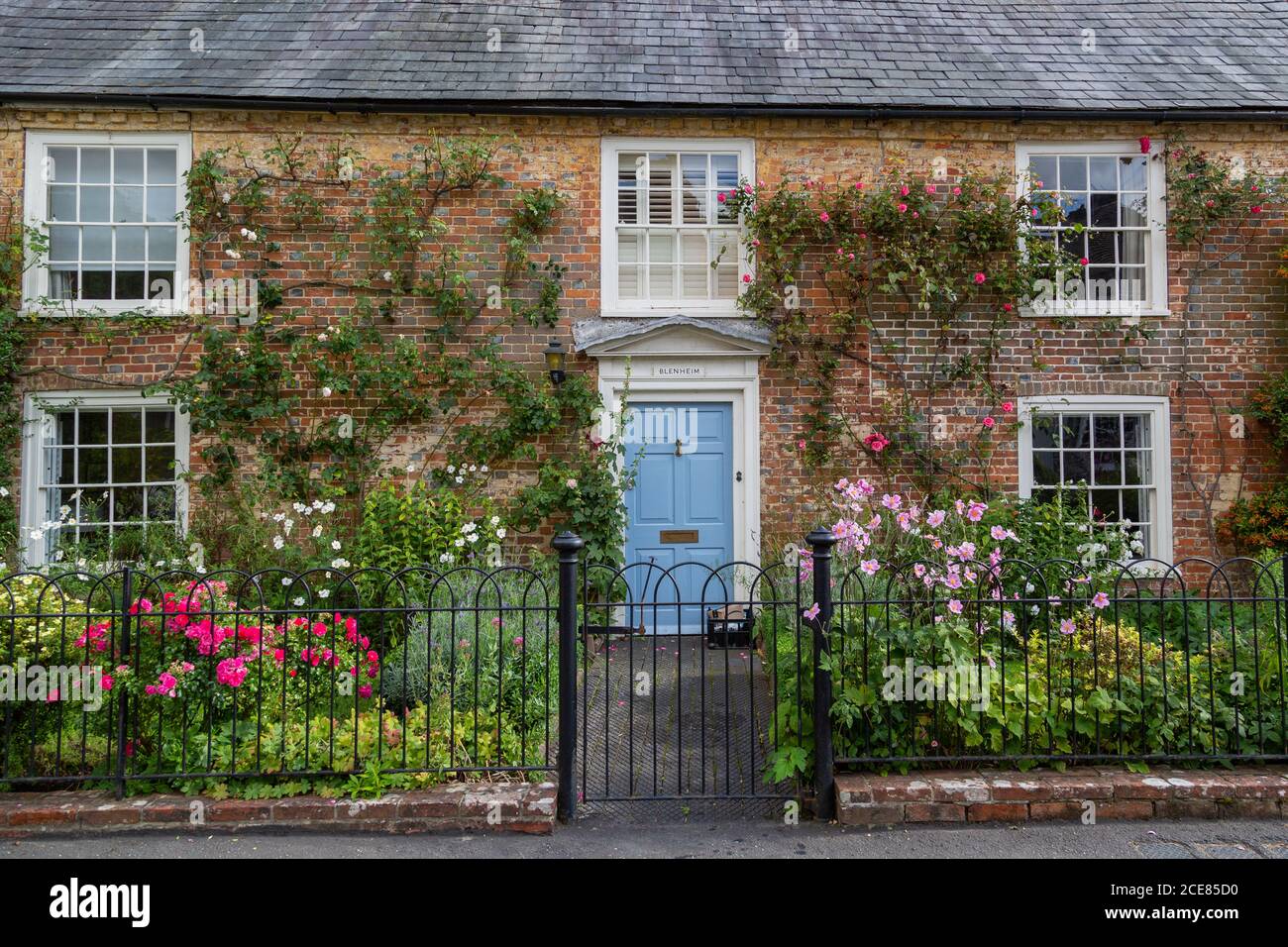 Das Äußere eines typisch englischen Landhauses im Sommer mit Blumen, die im Vorgarten, hambledon hampshire, blühen Stockfoto