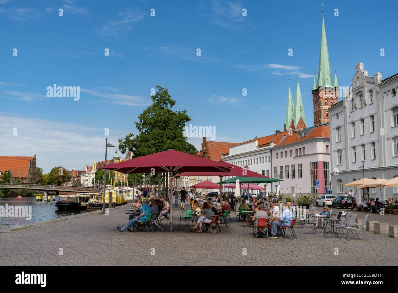 Lübeck, S-H / Deutschland - 9. August 2020: Menschen genießen einen Sommertag am Flussufer in der historischen Altstadt von Lübeck Stockfoto