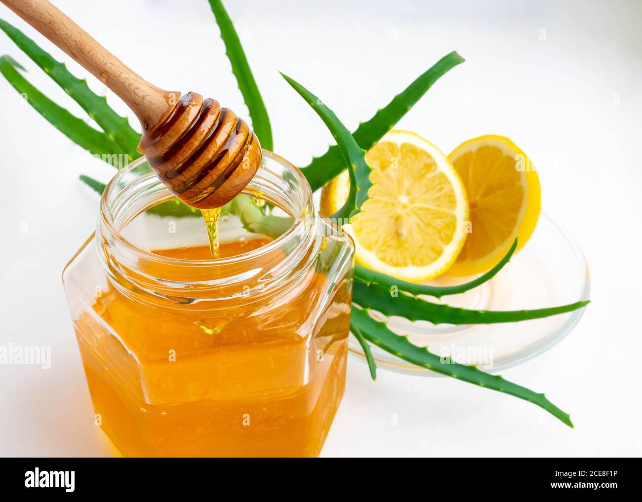 Nützliche Inhaltsstoffe zur Stärkung des Immunsystems auf weißem Hintergrund.Honig im Glas, Zitrone und Aloe Vera. Leerzeichen für Text Stockfoto