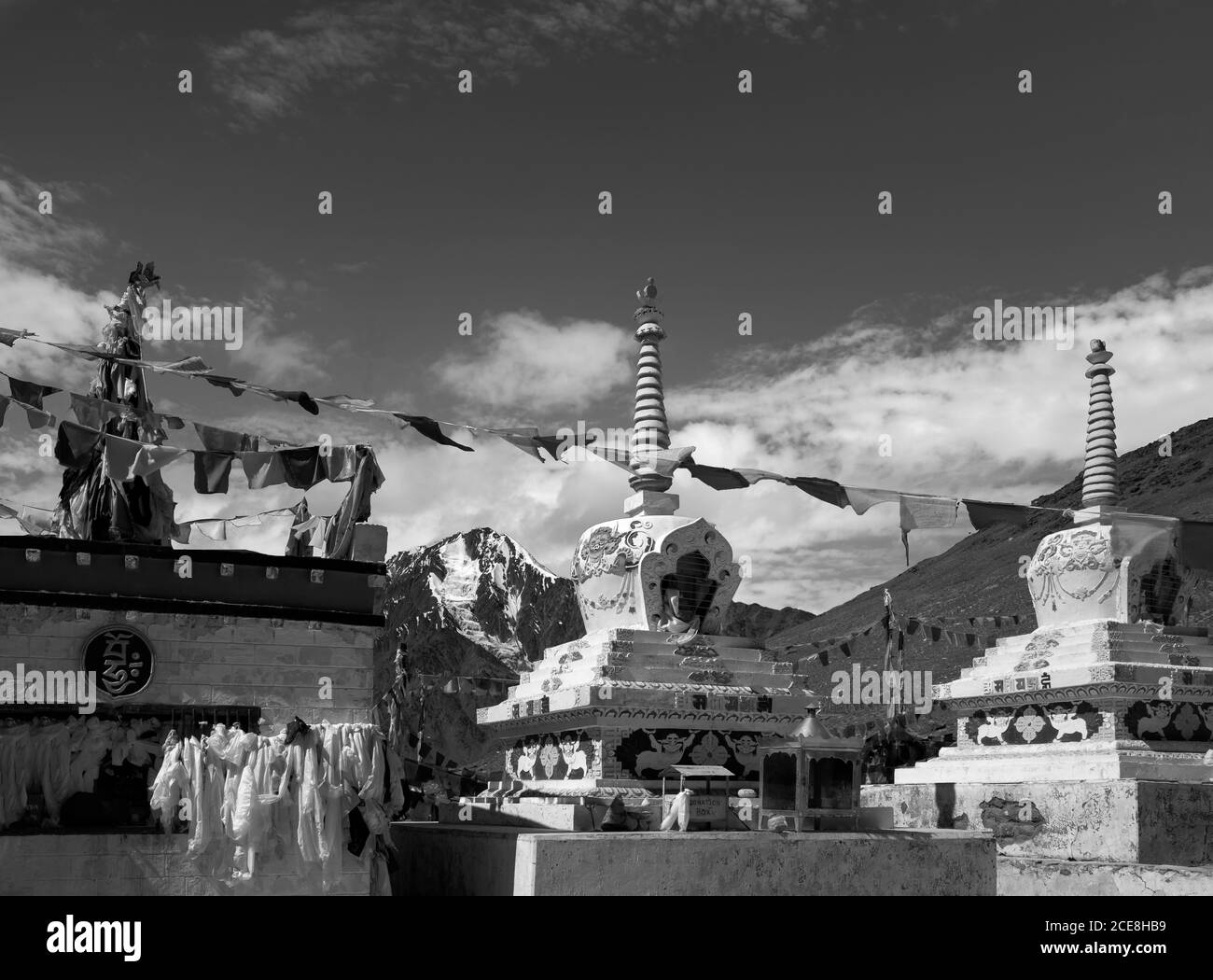 Buddhistische Stupas mit Gebetsfahnen über schneebedeckten Himalaya unter blauem Himmel zwischen Manali und Kaza, Himachal Pradesh, Indien. Stockfoto