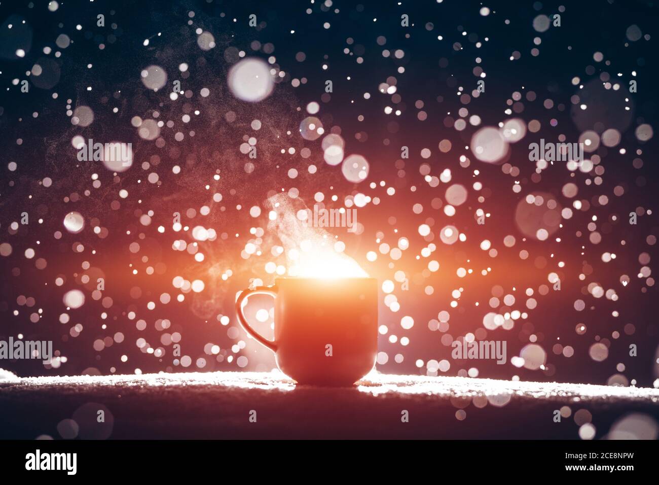 Hinterleuchtete Tasse heißen dampfenden Kaffee trinken oder Tee auf Nacht verschneiten Hintergrund Stockfoto