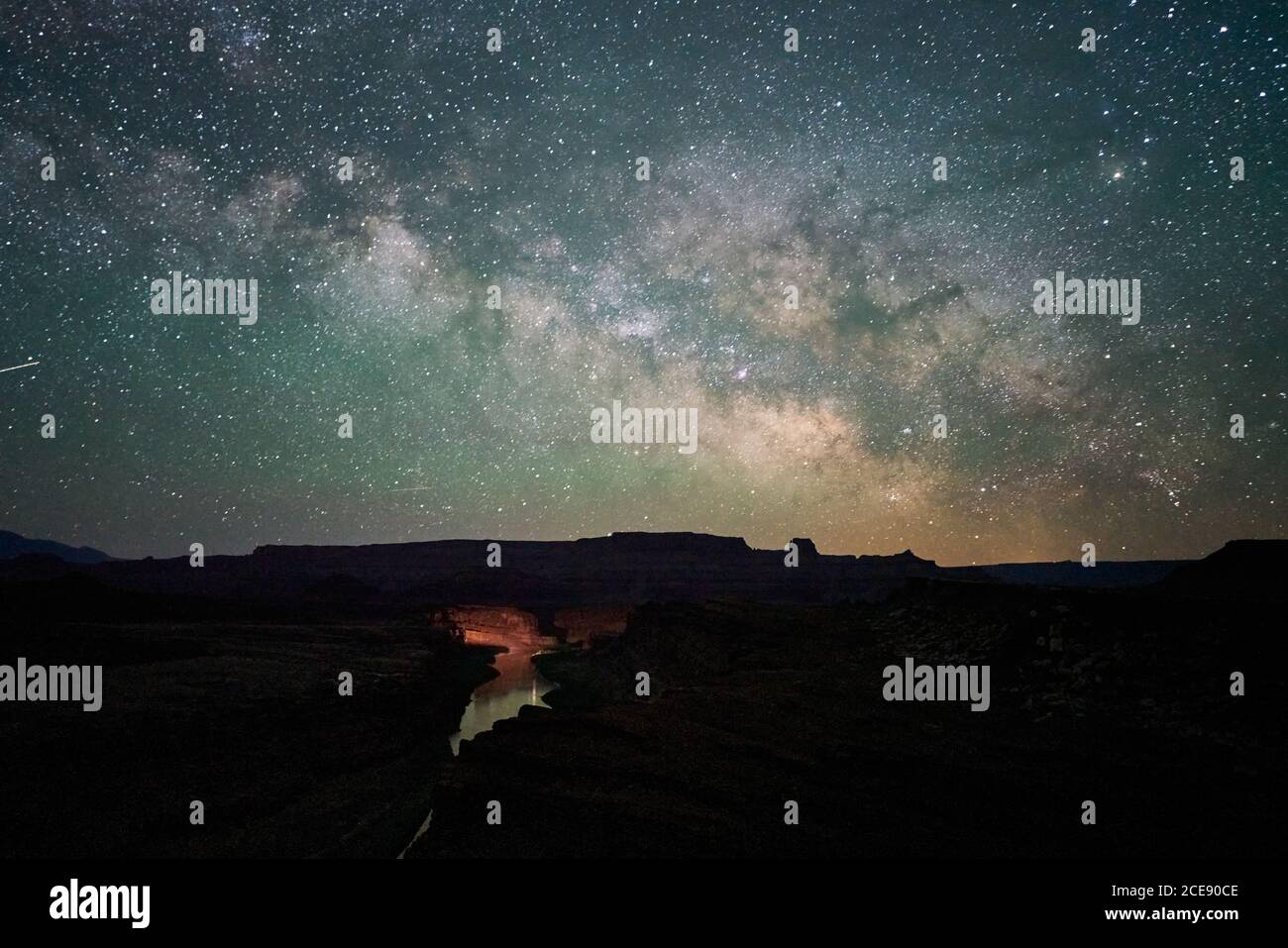 Spektakulärer Blick auf den leuchtenden Sternenhimmel mit Milchstraße Im Fluss, der in der Nacht zwischen dunklem felsigen Gelände fließt In den USA Stockfoto