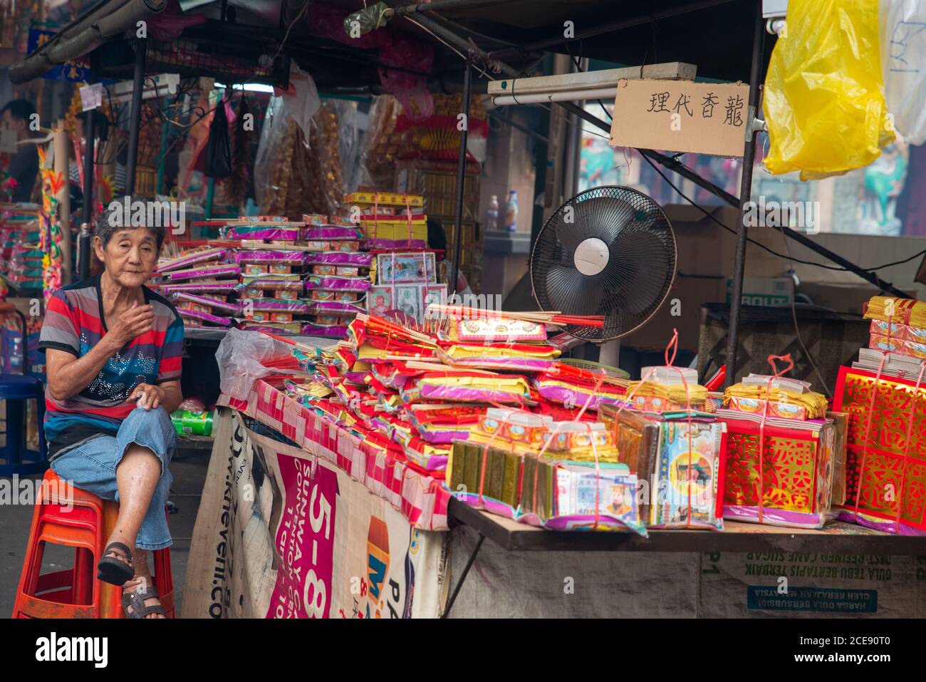 Bukit Mertajam, Penang/Malaysia - Aug 13 2016: Ein Falker sitzt neben dem Joss-Papier und dem Joss-Stick. Stockfoto