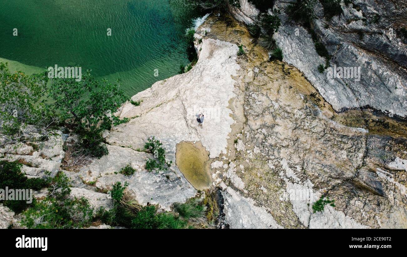 Atemberaubende Luftaufnahme der steinigen Küste mit grünen Bäumen in der Nähe Teich mit plätscherndem Wasser und unkenntliche Person, die mit fotografiert Kamera Stockfoto