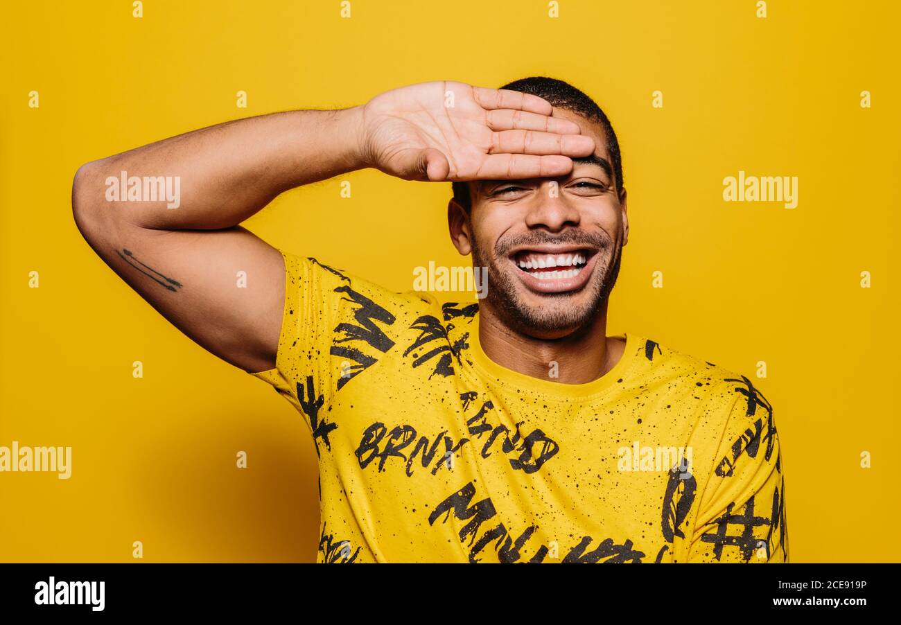Porträt eines fröhlichen Mannes lächelnd und Blick auf die Kamera über Einfarbiger gelber Hintergrund Stockfoto