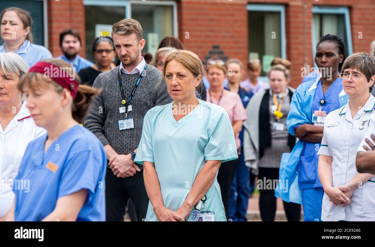NHS-Schlüsselarbeiter vor dem Harrogate District Hospital beobachteten eine Schweigeminute, um ihre Kollegen zu ehren, die ihr Leben an Covid 19 verloren. Stockfoto
