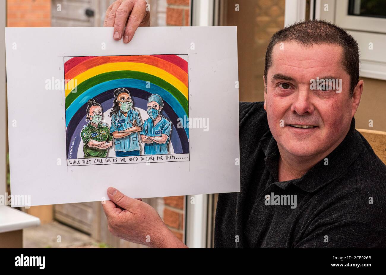 Zeichentrickkünstler und Illustrator Graeme Bandeira bei der Arbeit in seinem Heimstudio mit einem seiner vom NHS inspirierten Cartoons. Stockfoto