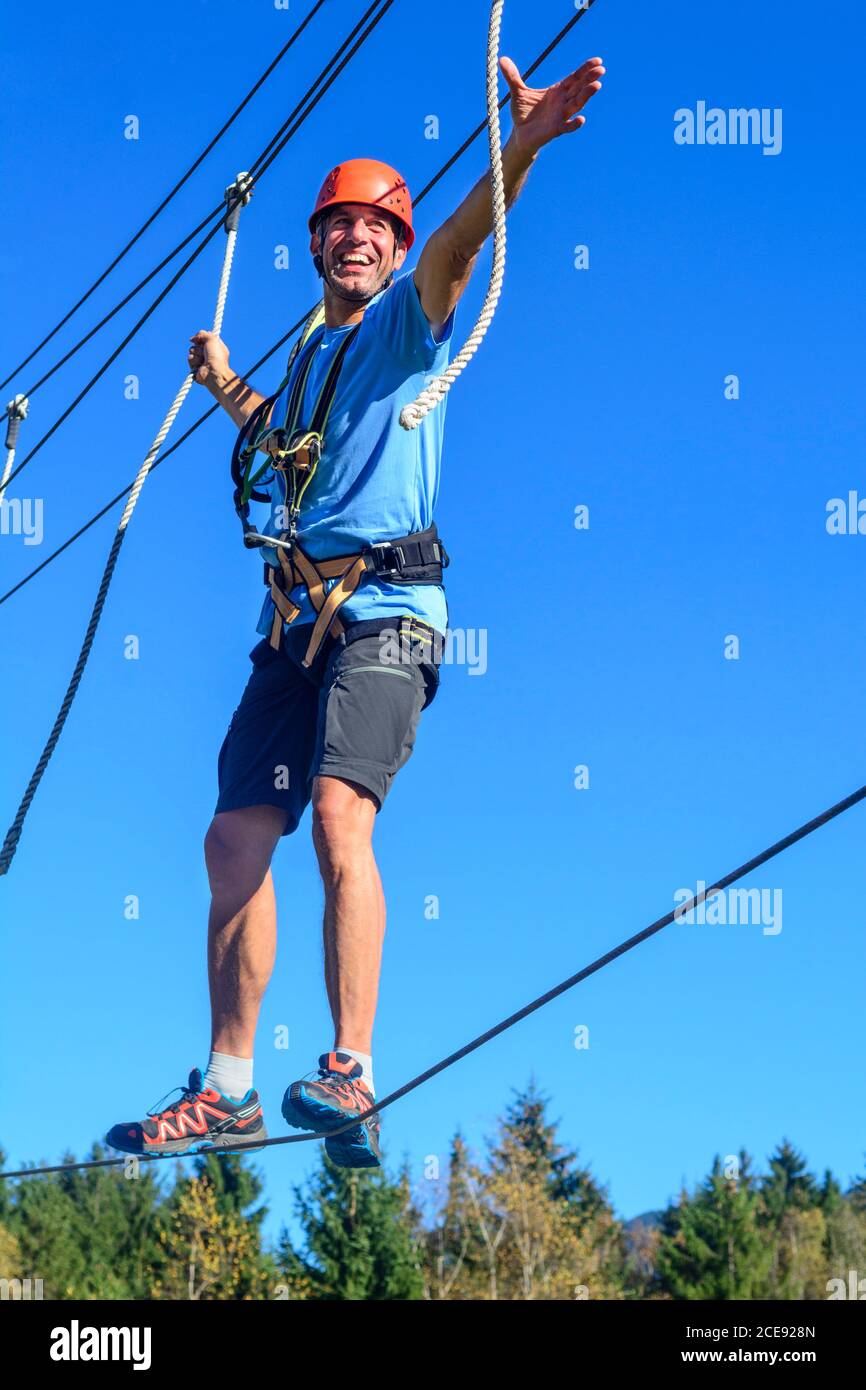 Man Balancieren auf hohem Seil im Hochseilgarten Stockfoto