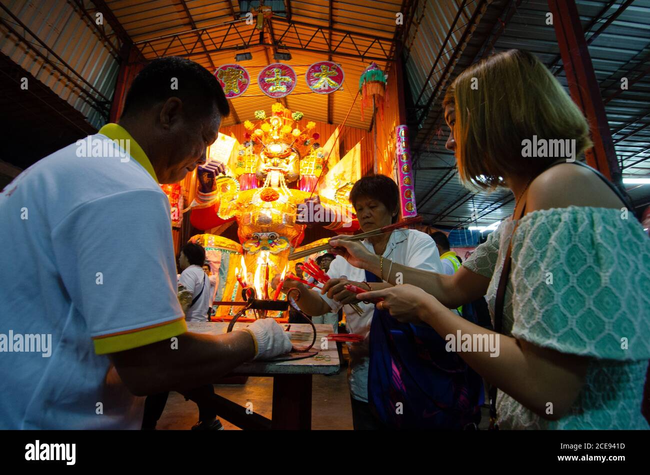 Bukit Mertajam, Penang/Malaysia - Aug 19 2016: Frauen verbrennen Joss Stick und Kerze vor der hungrigen Geisterstatue. Stockfoto