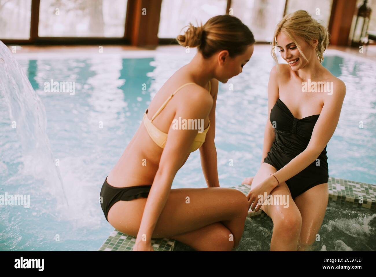 Hübsche junge Frauen sitzen und entspannen an der Whirlpool-Badewanne Stockfoto