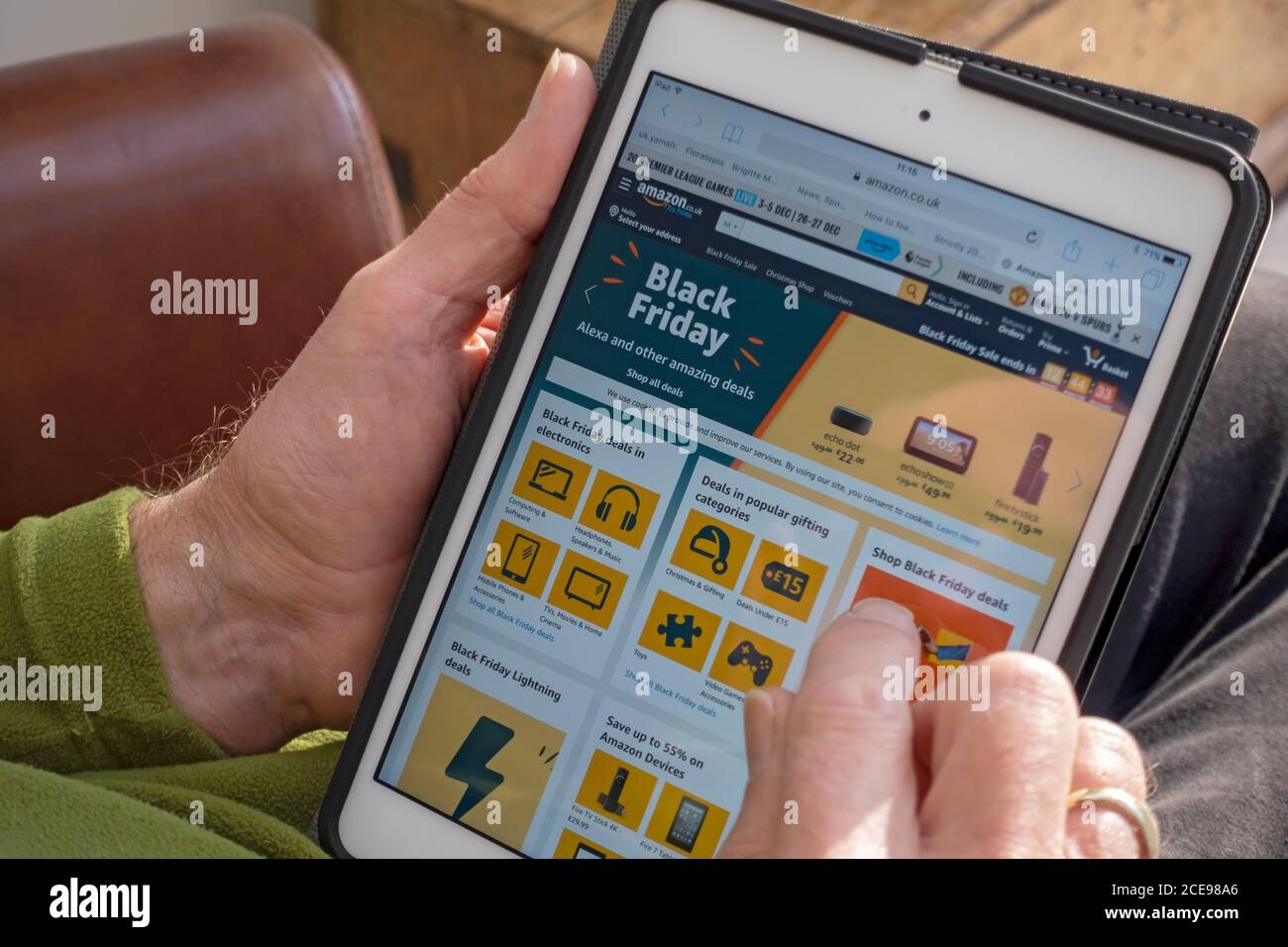 Nahaufnahme des Mannes, der auf der Amazon-Website-Homepage auf dem iPad schaut. Stockfoto