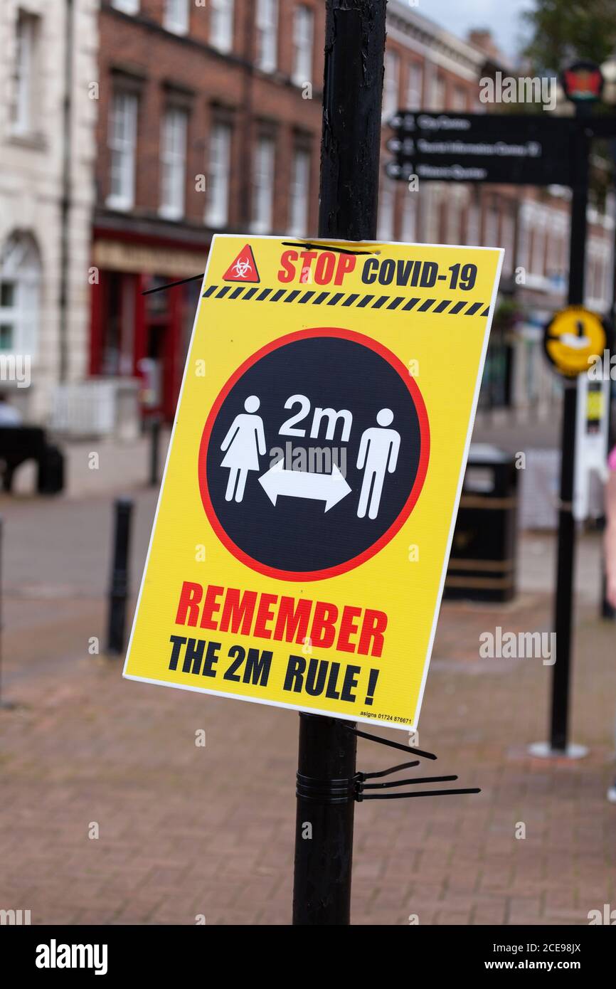 Stop covid 19 Denken Sie an die 2m Regel, Zeichen in Carlisle City Centre, Cumbria, Großbritannien Stockfoto