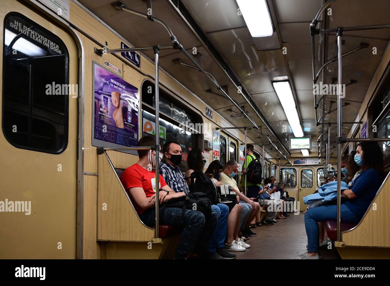 Fahrgäste in U-Bahn-Zügen fahren in Schutzmasken entsprechend den Anforderungen gesundheitlicher Maßnahmen. Stockfoto