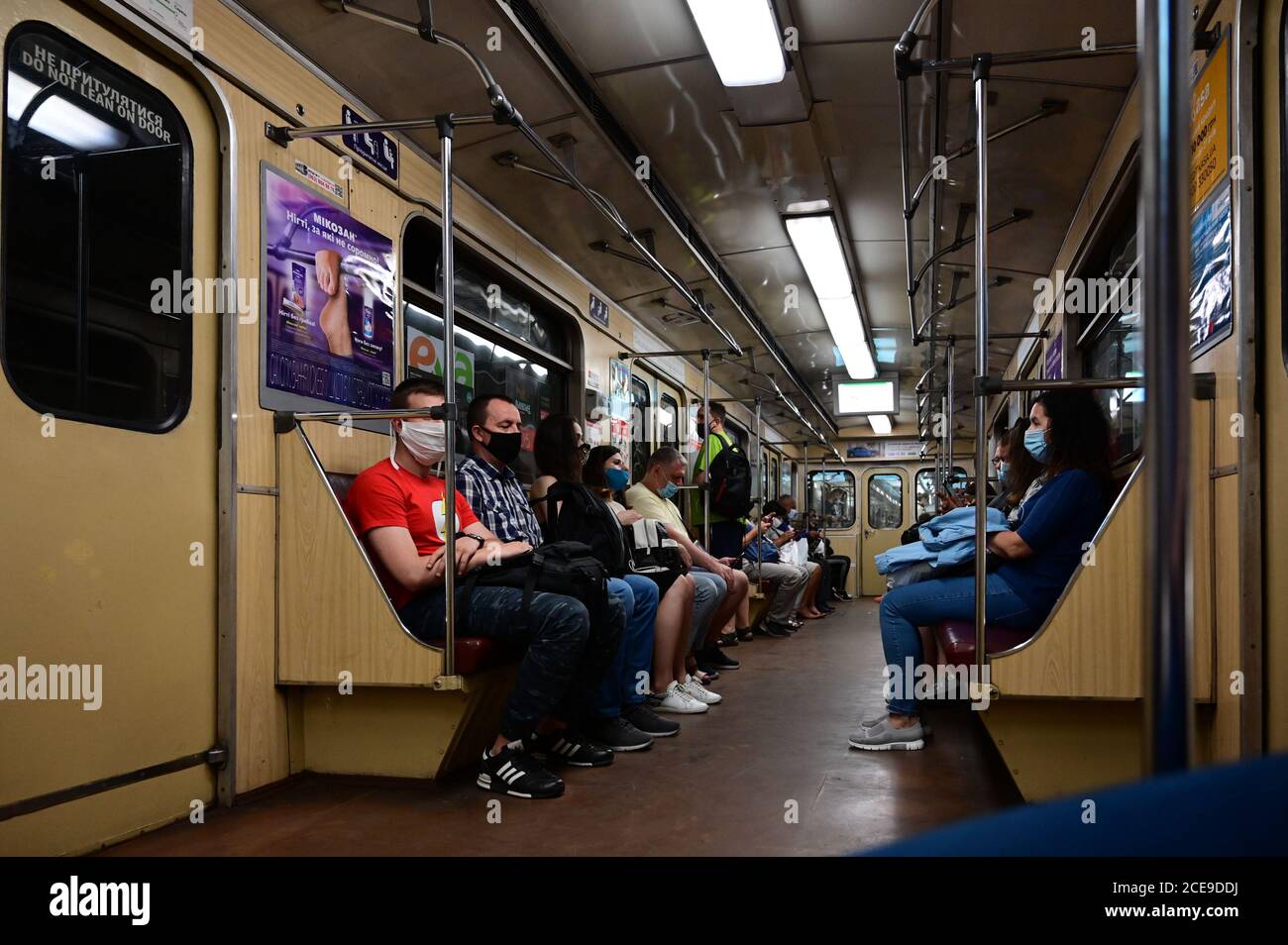 Fahrgäste in U-Bahn-Zügen fahren in Schutzmasken entsprechend den Anforderungen gesundheitlicher Maßnahmen. Stockfoto