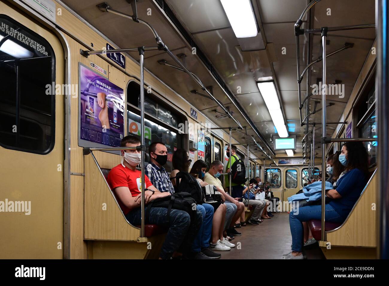 Fahrgäste in U-Bahn-Zügen fahren in Schutzmasken entsprechend den Anforderungen gesundheitlicher Maßnahmen. Stockfoto