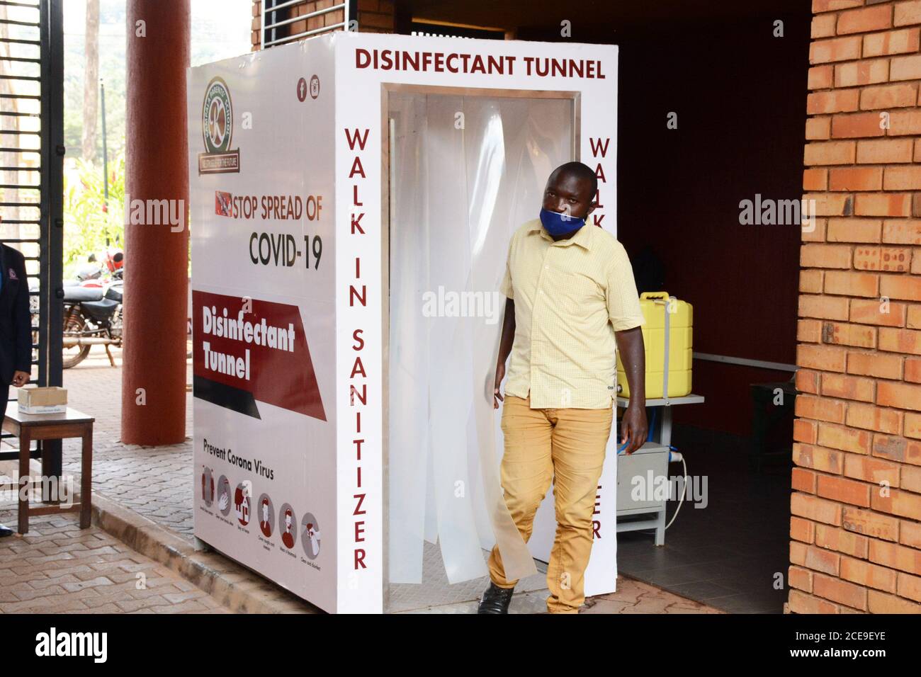 Kampala, Uganda. August 2020. Ein Mann passiert einen Desinfektionstunnel an der Kampala-Elternschule in Kampala, Uganda, 31. August 2020. Ugandas nationale Taskforce, die den Kampf gegen die COVID-19-Pandemie anführen soll, soll die Wiedereröffnung von Schulen überprüfen, nachdem sie im März nach dem Ausbruch des Virus im Land geschlossen wurden, sagte ein Regierungsoberster am Sonntag. Quelle: Nicholas Kajoba/Xinhua/Alamy Live News Stockfoto