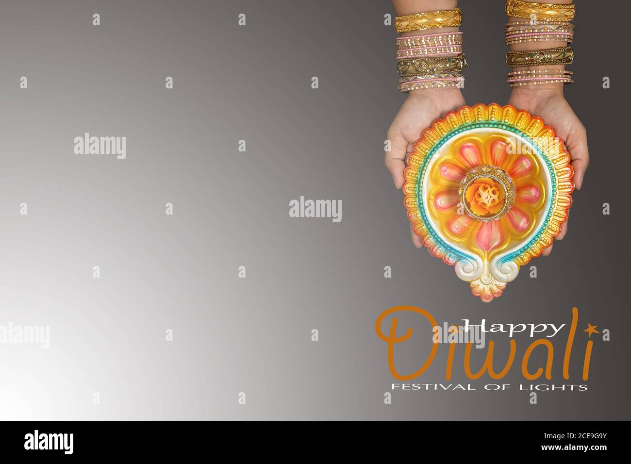 Happy Diwali - Frau Hände mit Henna halten brennende Kerze isoliert auf grauem Hintergrund. Hinduistisches Lichterfest. Platz für Text kopieren. Stockfoto