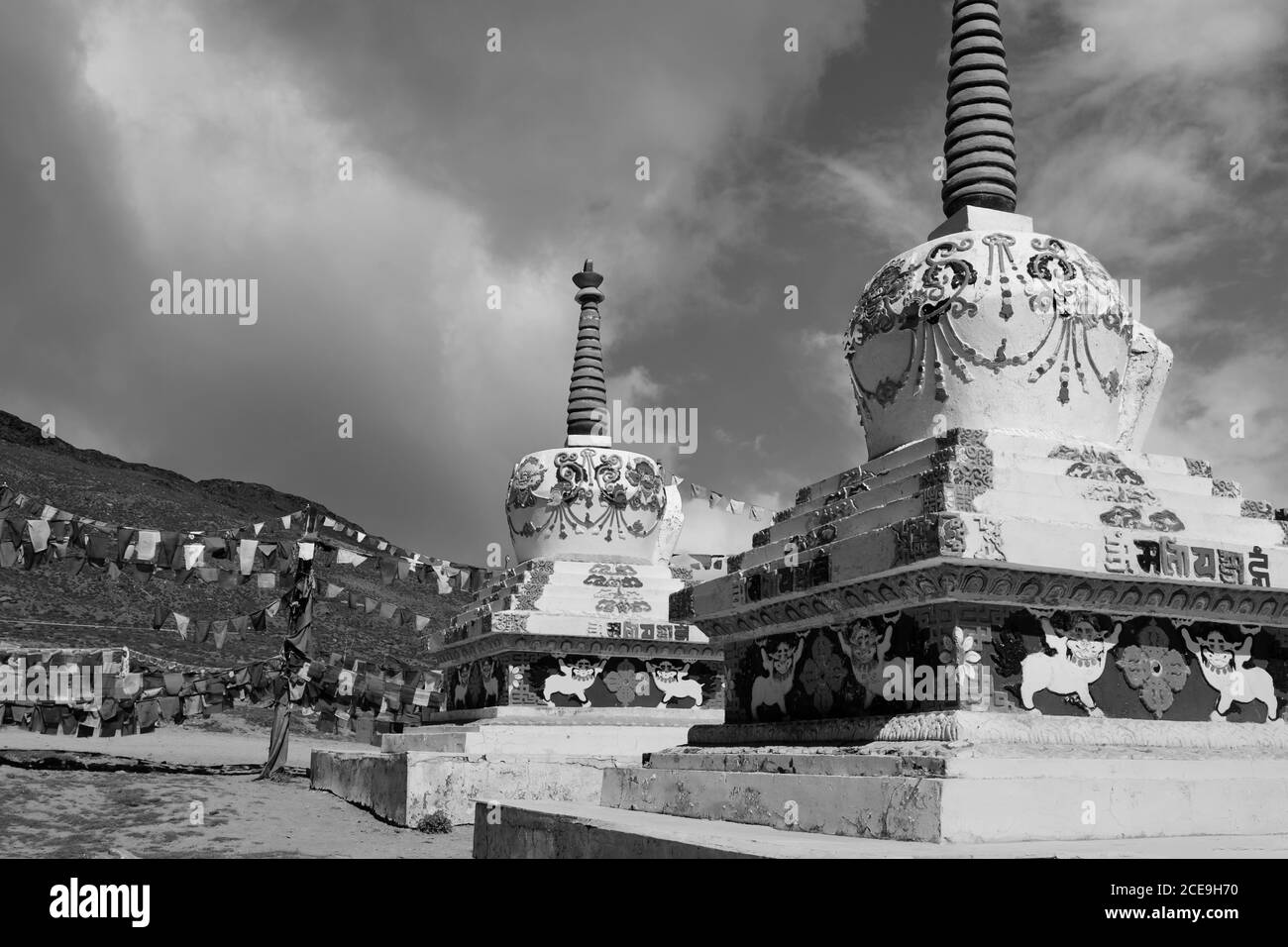 Buddhistische Stupas mit Gebetsfahnen über schneebedeckten Himalaya unter blauem Himmel zwischen Manali und Kaza, Himachal Pradesh, Indien. Stockfoto