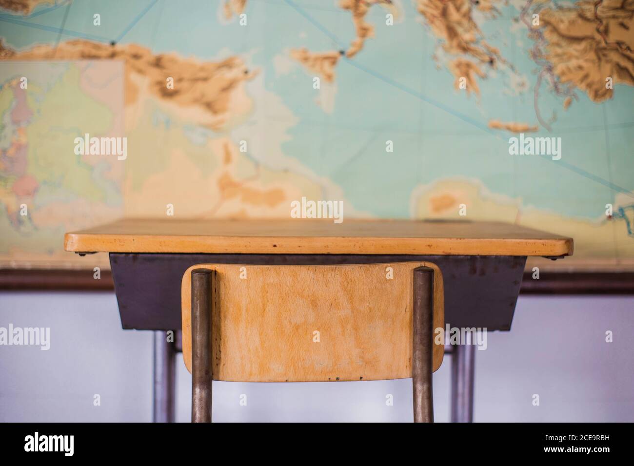 Leere Schreibtische in der Schule Klassenzimmer mit Weltkarte. Stockfoto