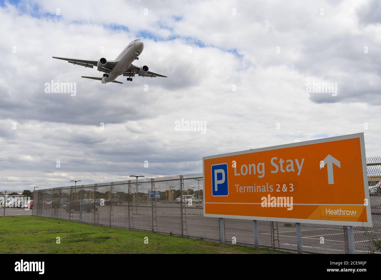 Langzeitparkplätze am Flughafen Heathrow mit einem Flugzeug, das über dem Parkplatz fliegt. London Stockfoto