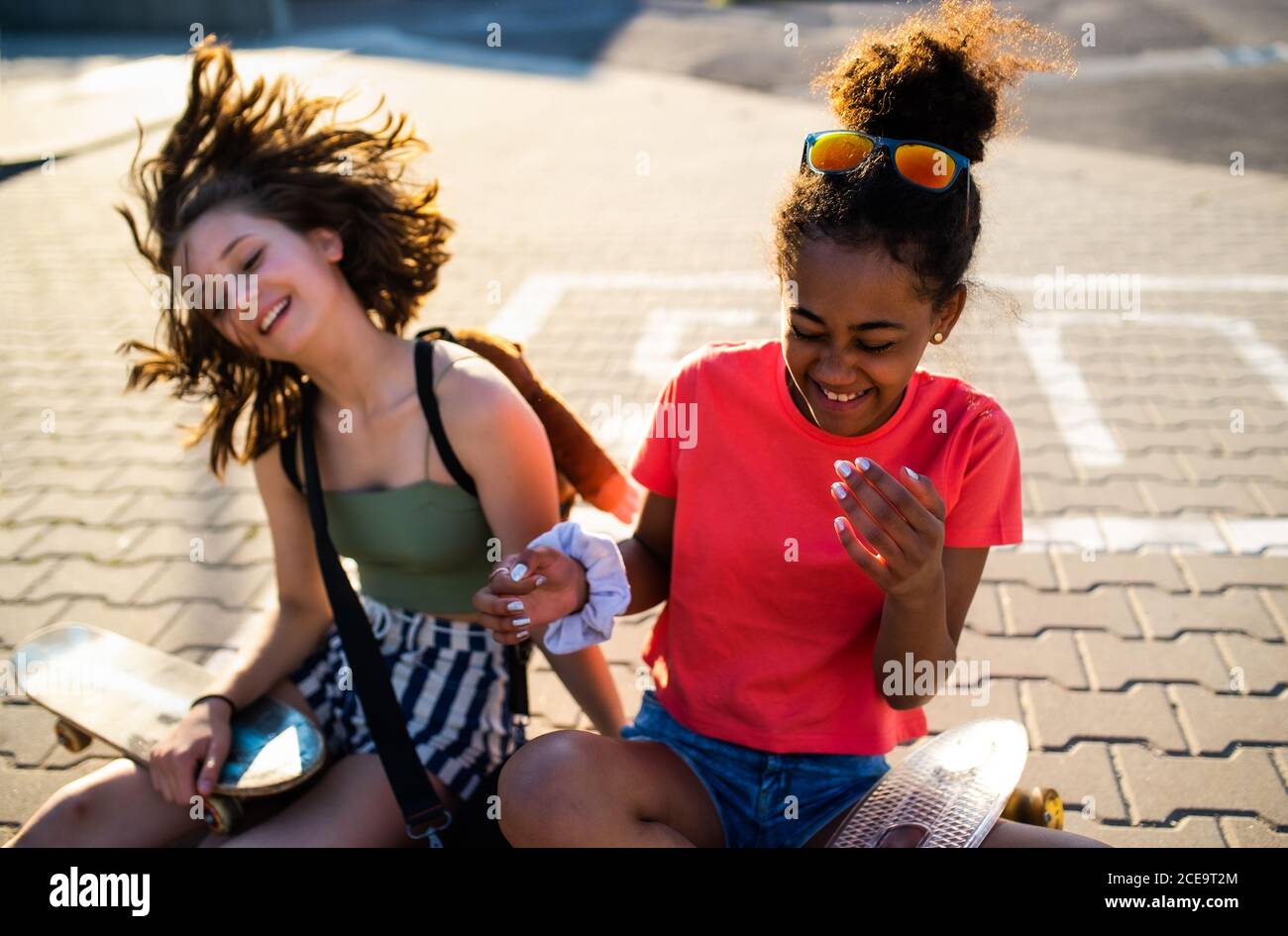 Teenager Mädchen Freunde mit Skateboards sitzen im Freien in der Stadt. Stockfoto