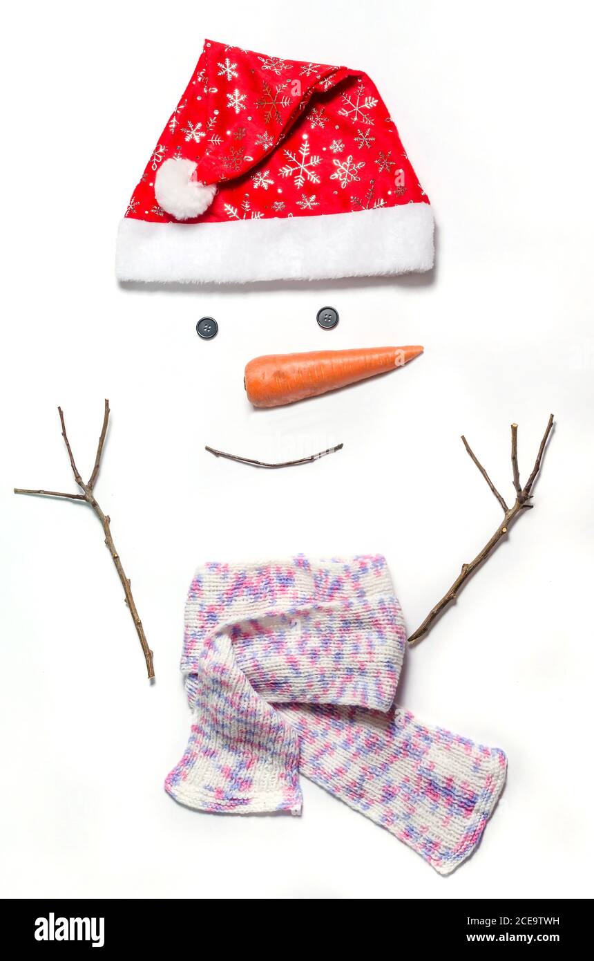 Schneemann Gesicht auf weißem Hintergrund. Ein Satz von Gegenständen für die Herstellung eines Schneemann - ein roter Hut, ein Schal, Karotten, Augen - Tasten, Zweige. Wie man ein Stockfoto