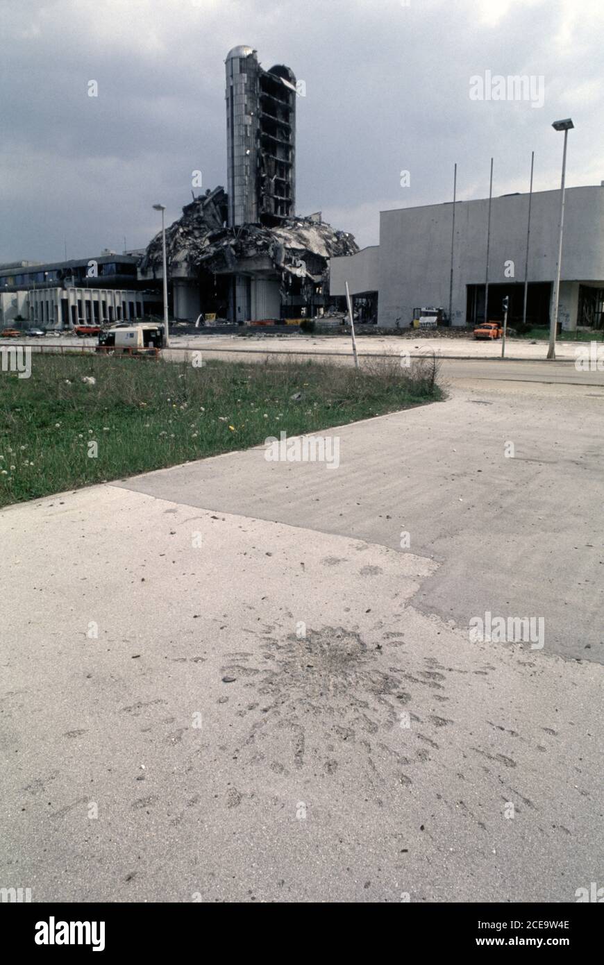 27. April 1994 während der Belagerung von Sarajevo: Eine 'Sarajevo Rose', die allgegenwärtige Narbe einer bosnisch-serbischen Mörserbombe, in der Nähe der Ruinen des Oslobodenje Zeitungsgebäudes in der Dzemala Bijedica Straße. Stockfoto