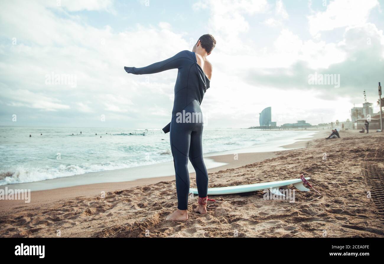 Nicht erkennbarer Mann in Nassanzug am Strand Stockfoto