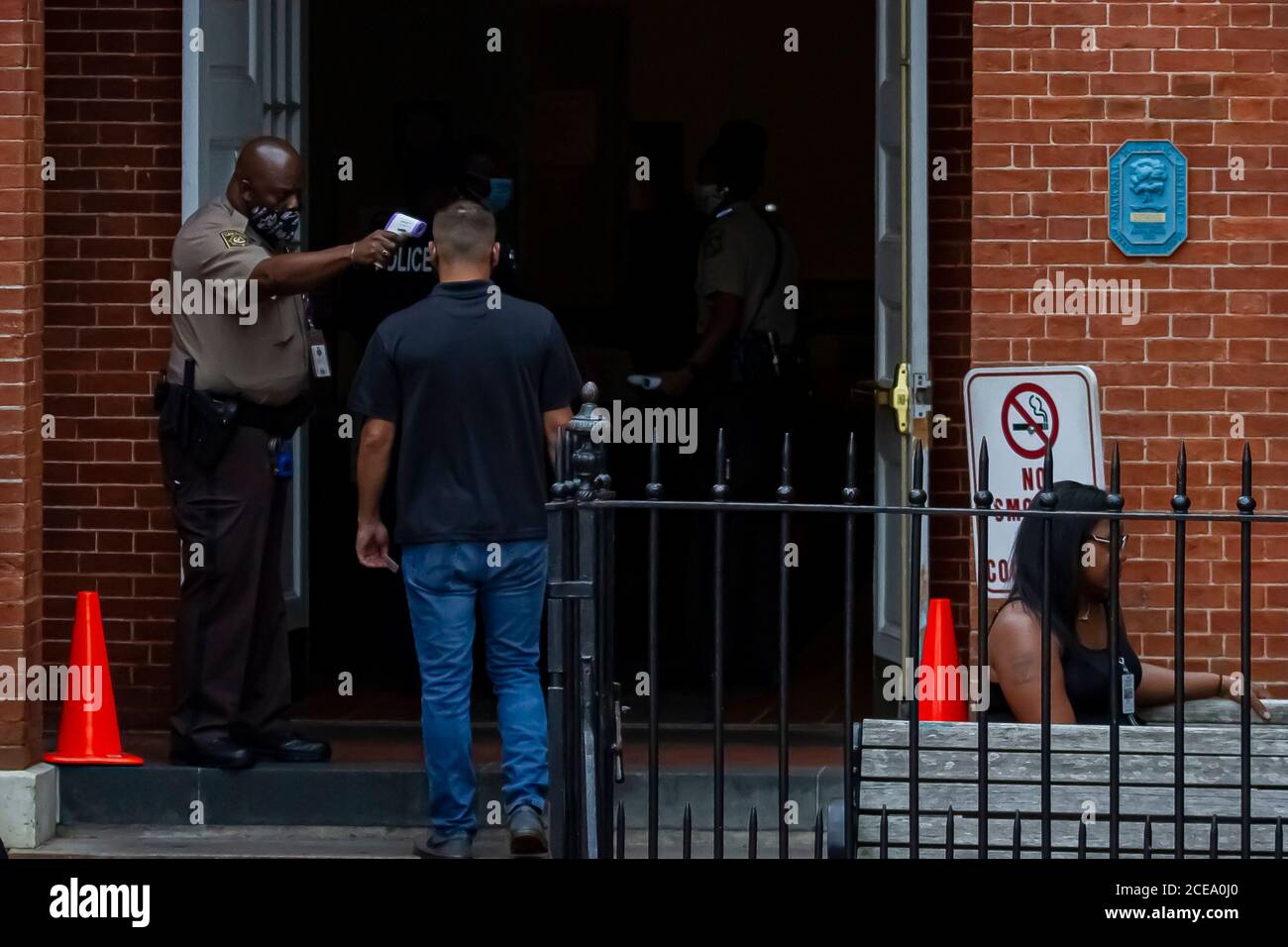 Annapolis, MD 08/21/2020: Polizeibeamte mit Sheriff-Abzeichen, die Gesichtsmaske tragen, sind am Eingang des Bezirksgerichts von Anne Arundel im Dienst. Sie Stockfoto
