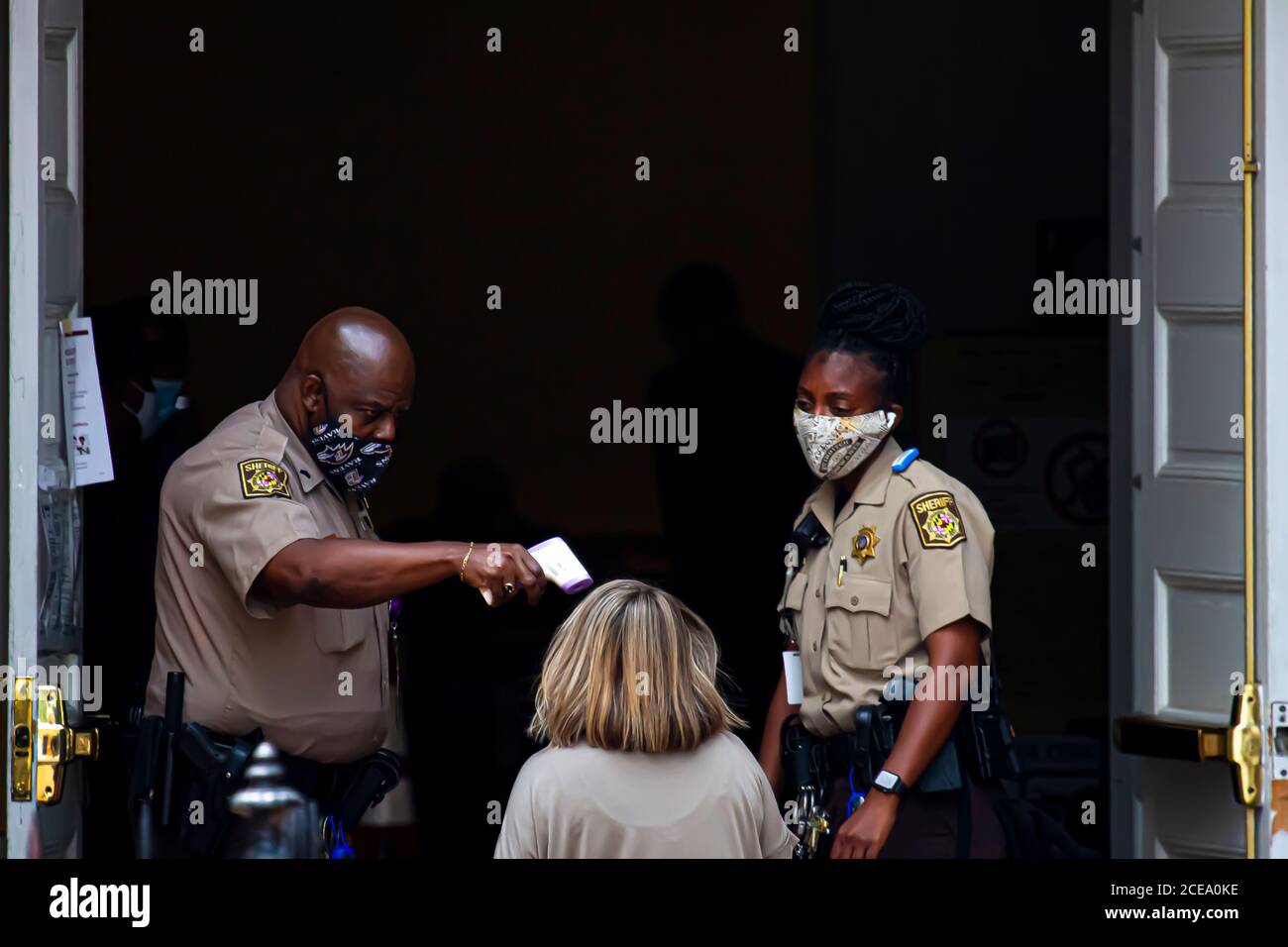 Annapolis, MD 08/21/2020: Polizeibeamte mit Sheriff-Abzeichen, die Gesichtsmaske tragen, sind am Eingang des Bezirksgerichts von Anne Arundel im Dienst. Sie Stockfoto