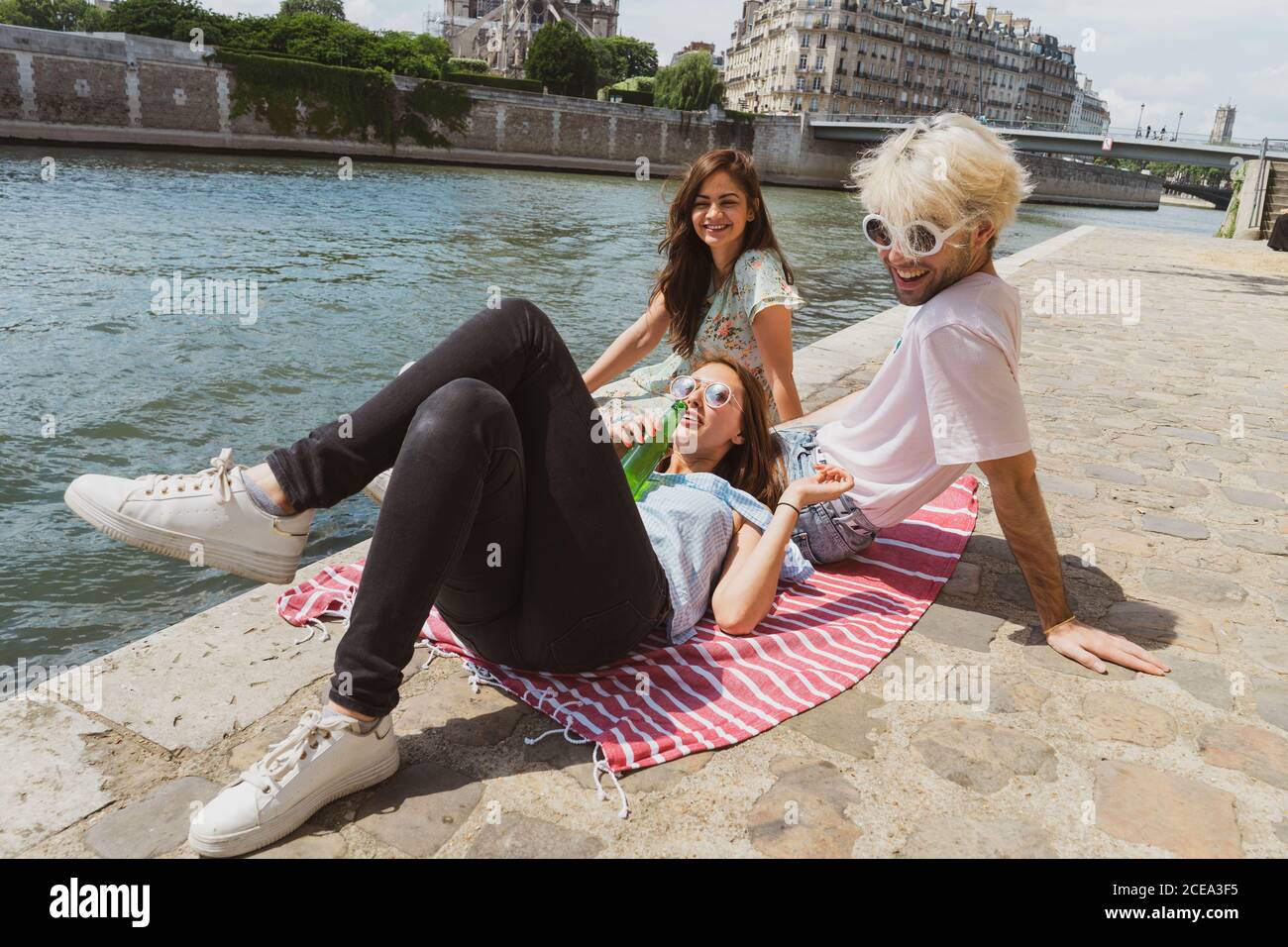 Lächelnde Freunde entspannen am Wasser Stockfoto