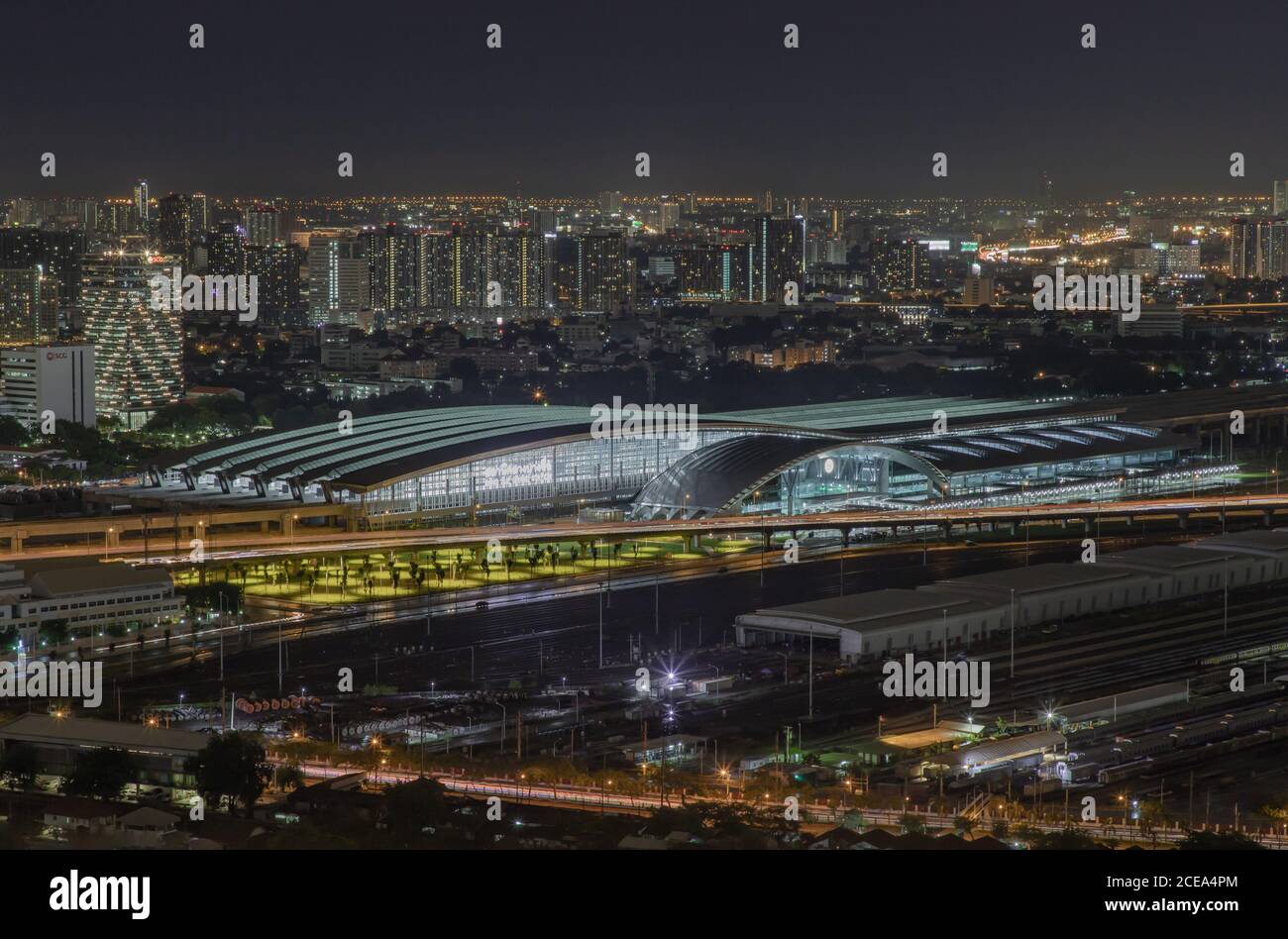 Bangkok, thailand - Aug 28, 2020 : Luftaufnahme des Bang Sue Hauptbahnhofs mit Wolkenkratzern im Hintergrund bei Nacht. Selektiver Fokus. Stockfoto