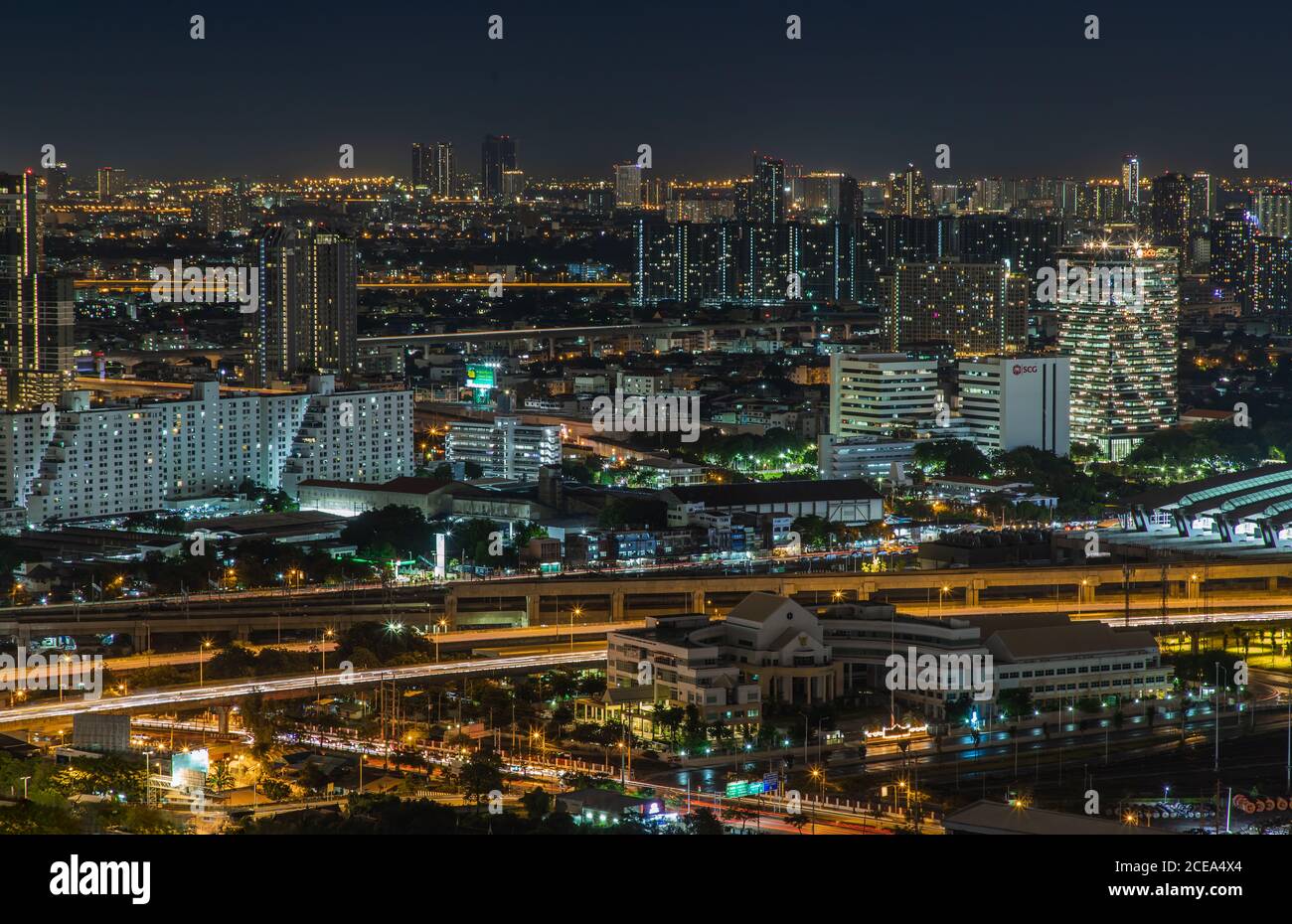 Bangkok, thailand - Aug 28, 2020 : Luftaufnahme des Bang Sue Hauptbahnhofs mit Wolkenkratzern im Hintergrund bei Nacht. Selektiver Fokus. Stockfoto