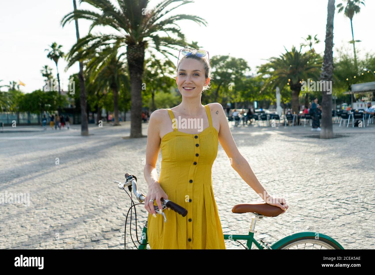 Frau in Sommerkleidung lehnt auf Fahrrad Stockfoto
